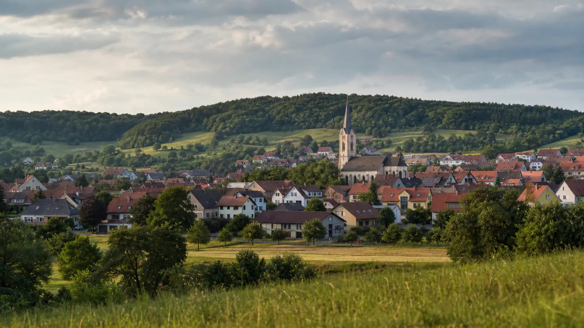 Oberasbach mit Kirche, Dächern und grünen Hügeln bei Tageslicht